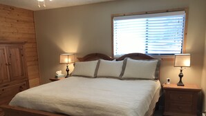 A bedroom with a wooden bed, two bedside tables with lamps, a wooden wardrobe, and a window with blinds. - On Golf Course, 4 Bedrooms, 3 bathrooms, Sleeps 10 (Angel Fire)