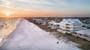 A beachfront property with multiple buildings, a boardwalk, and a sandy beach.