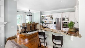 A modern kitchen with white cabinetry, a granite countertop, and stainless steel appliances. - Private heated pool + 1 block from beach + Pet Friendly (Folly Beach)