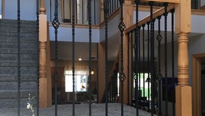 A multi-level interior with a wooden staircase and black balusters. - - Pikes Peak/Garden of the Gods!  Booking FAST! (Colorado Springs)