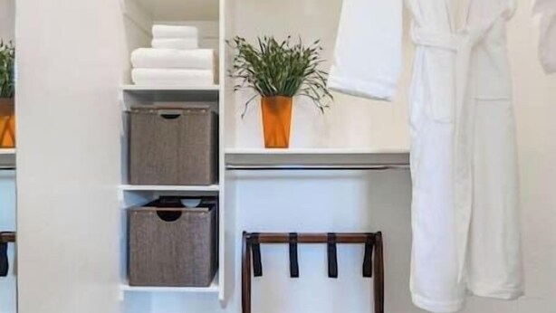 A walk-in closet with shelves, a bench, and a hanging robe rack. - Unique Apartment in Downtown Provo (Unit #11) (Provo)