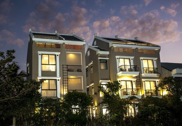 A modern two-story building with balconies, large windows, and solar panels. - Hoi An Silk River Villa (Da Nang)