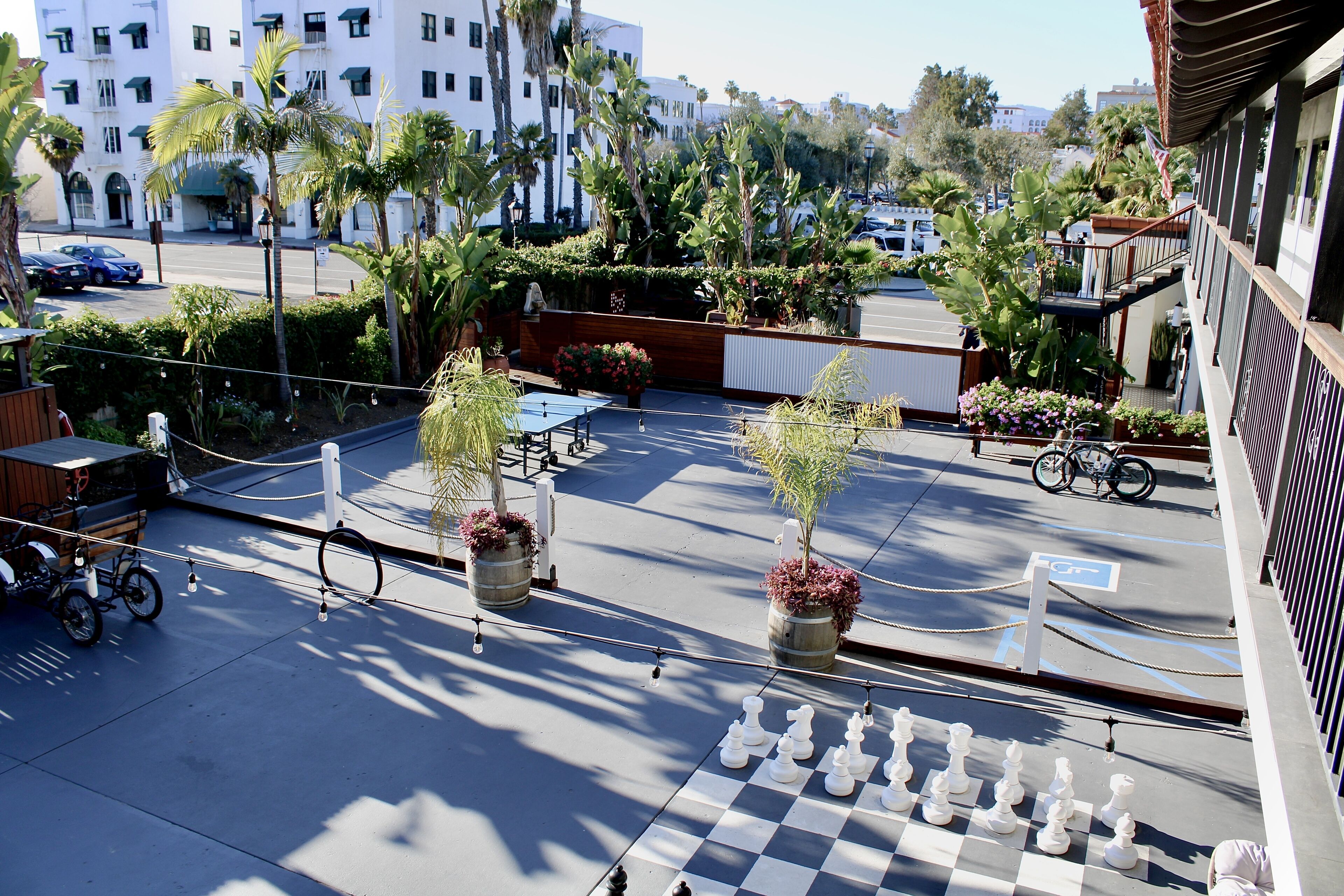 A chessboard set up on a balcony with a view of a street and buildings.