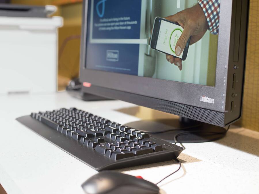 A computer monitor displaying a person using a smartphone.