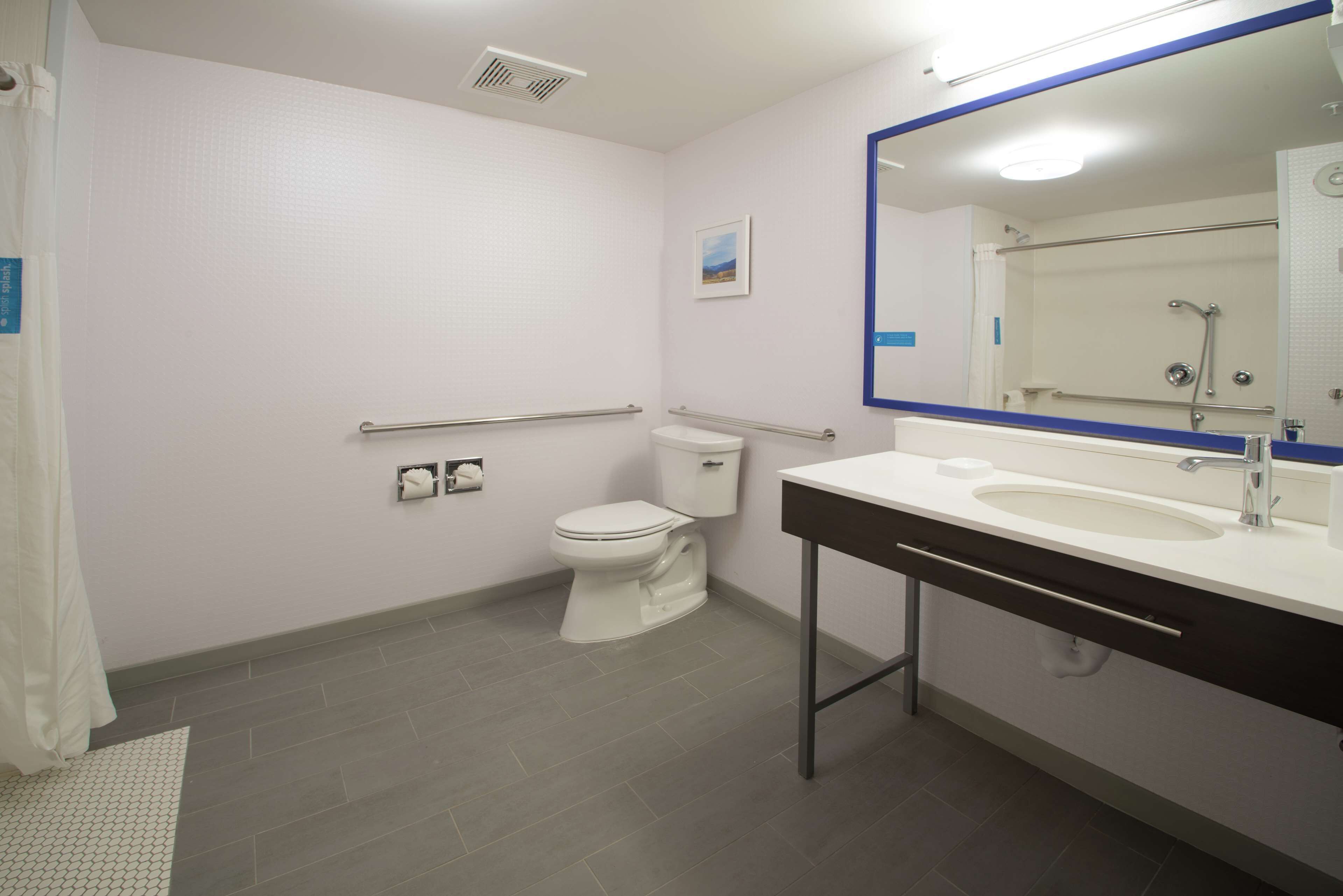 A modern bathroom with a toilet, sink, and shower area.