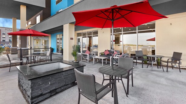 An outdoor patio with seating, a bar area, and red umbrellas. - TownePlace Suites by Marriott Edmonton Sherwood Park (Sherwood Park)