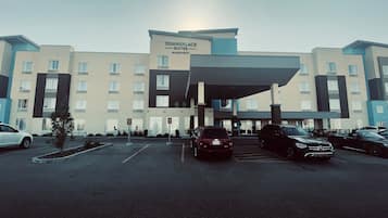 A Towneplace Suites Marriott hotel with a parking lot and several cars.