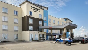 A Towneplace Suites Marriott hotel with a parking lot, a gas station, and a blue car parked in front. - TownePlace Suites by Marriott Edmonton Sherwood Park (Sherwood Park)