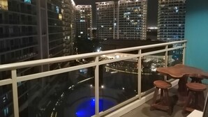 Un balcon offrant une vue sur les gratte-ciel la nuit.