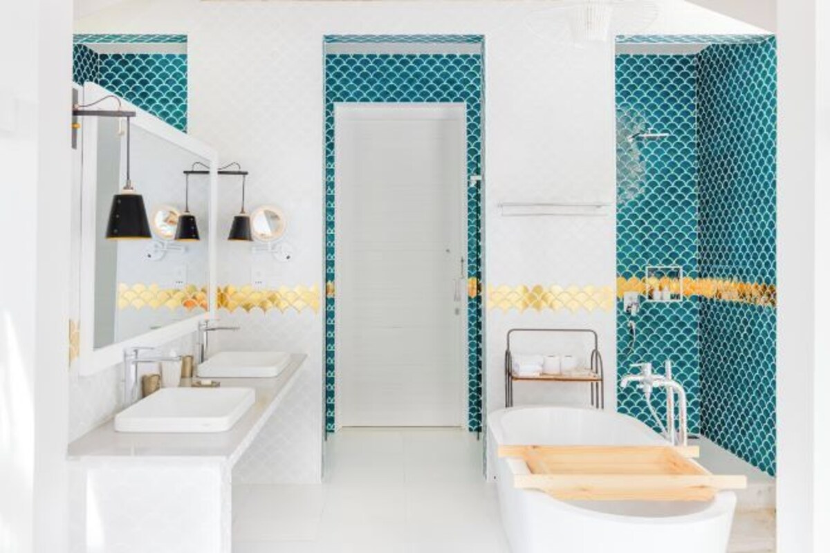 A modern bathroom with two sinks, a bathtub, and a shower.