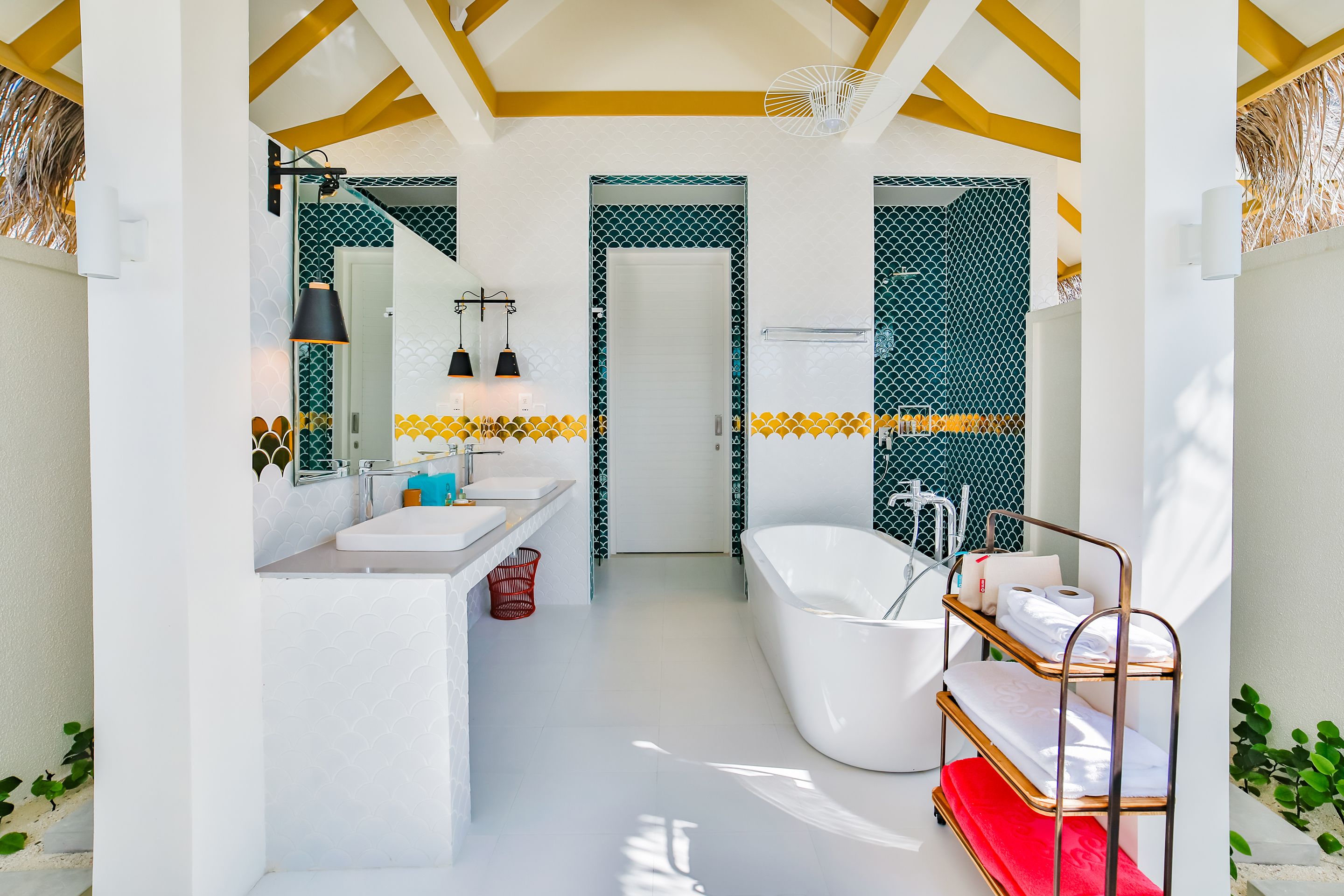 A modern bathroom with a white sink, a freestanding bathtub, and a vanity with a mirror.