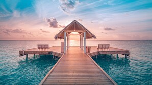 A wooden pier leading to a thatched-roof structure with two benches on either side. - Sun Siyam Iru Veli - 24 Hours All-Inclusive (Aloofushi)