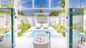 A modern bathroom with a freestanding bathtub, a small pool, and a seating area with a view of the pool. - Sun Siyam Iru Veli - 24 Hours All-Inclusive (Aloofushi)