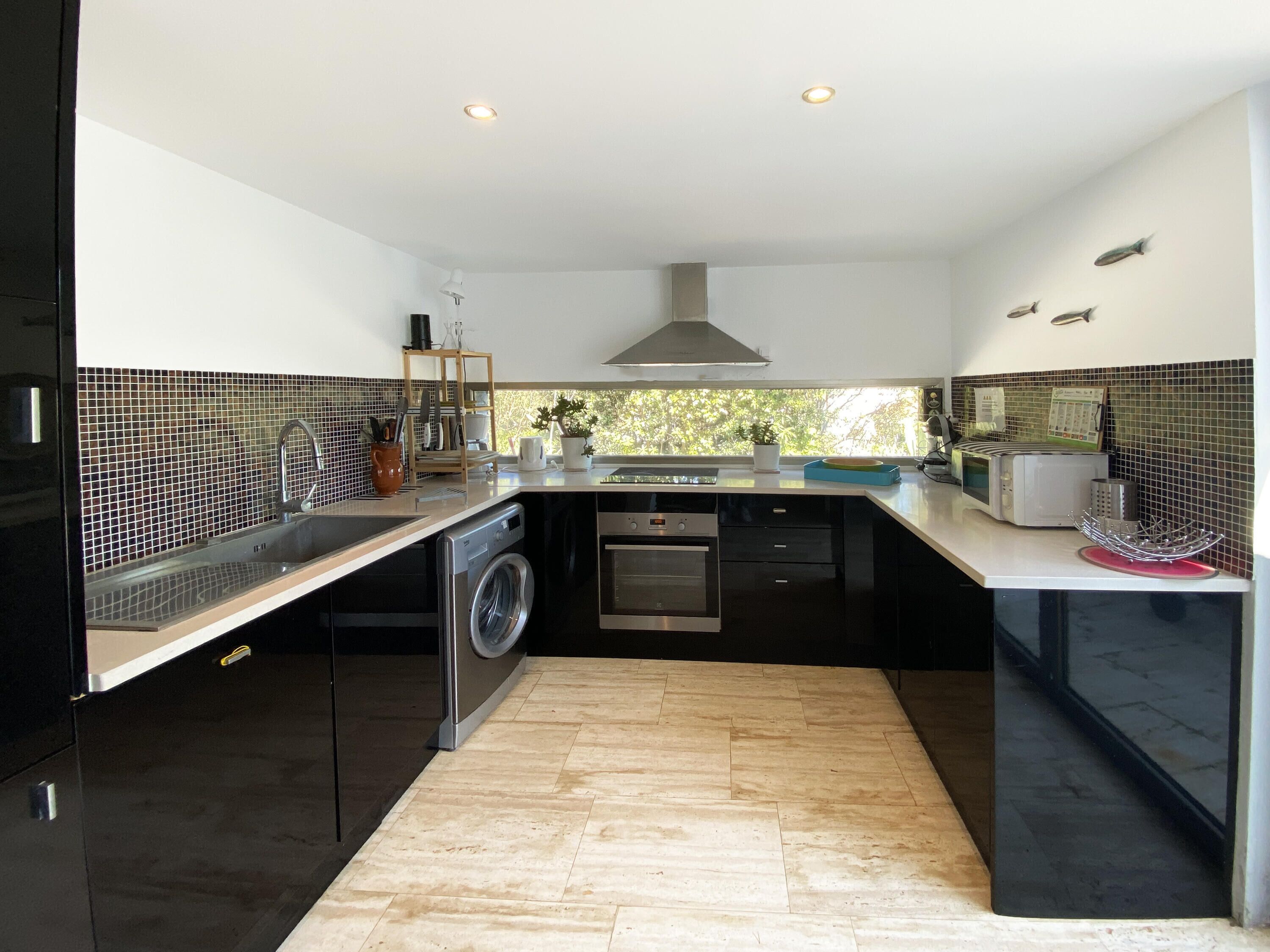 A modern kitchen with a built-in washing machine, a microwave, and a toaster.