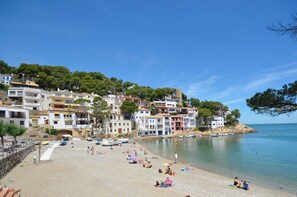 A beach with buildings on a hillside, clear skies, and calm water. - Holiday rental villa with swimming pool in Begur, Sa Riera (Begur)