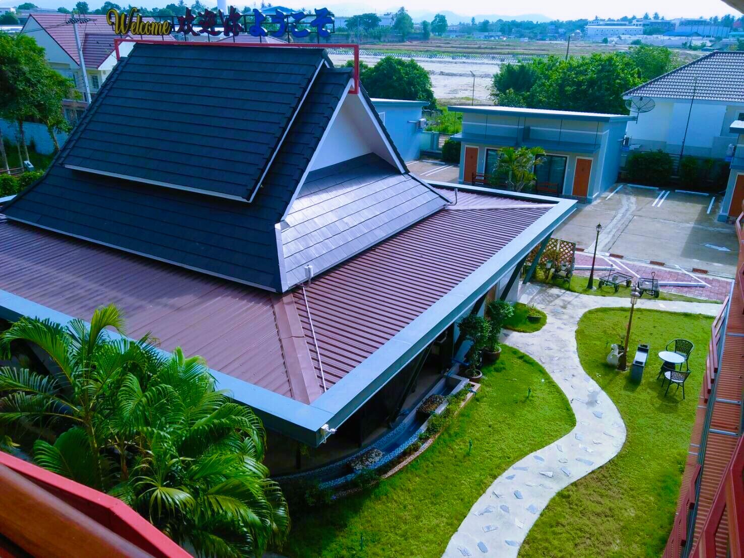 A modern building with a sloped roof and a landscaped garden area with a pathway and seating.
