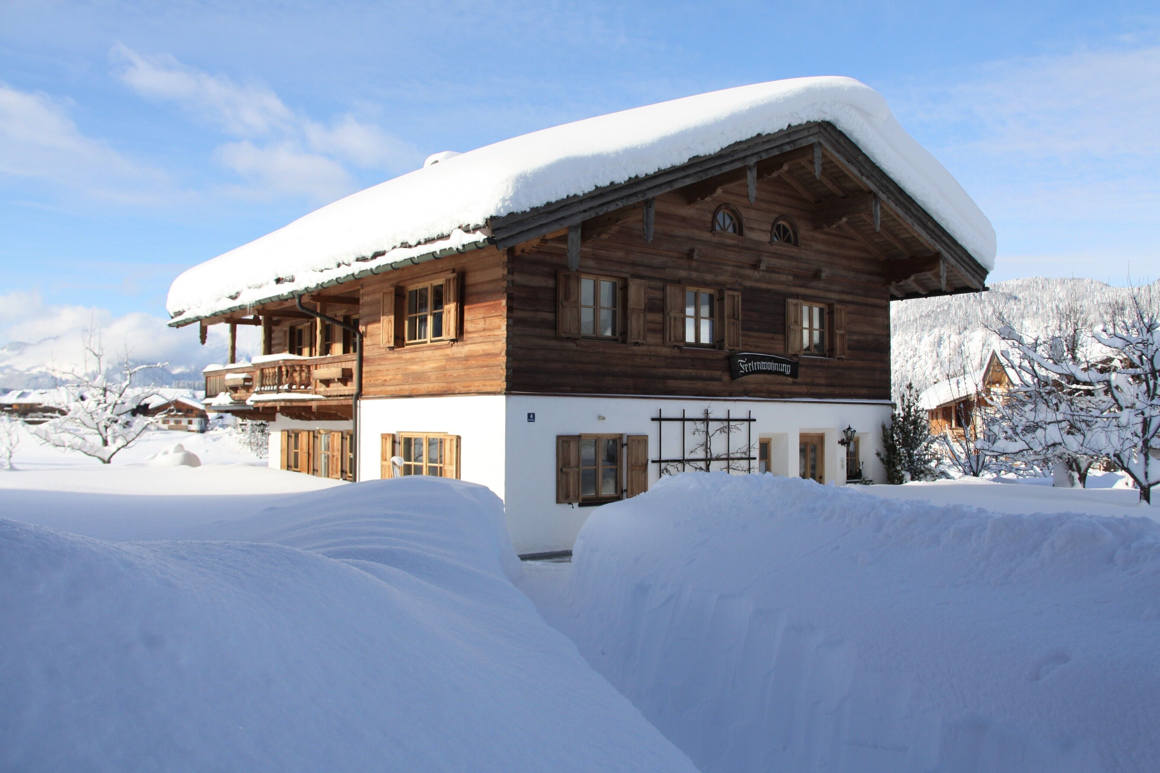 A wooden chalet with a snow-covered roof and a sign indicating it is a restaurant.