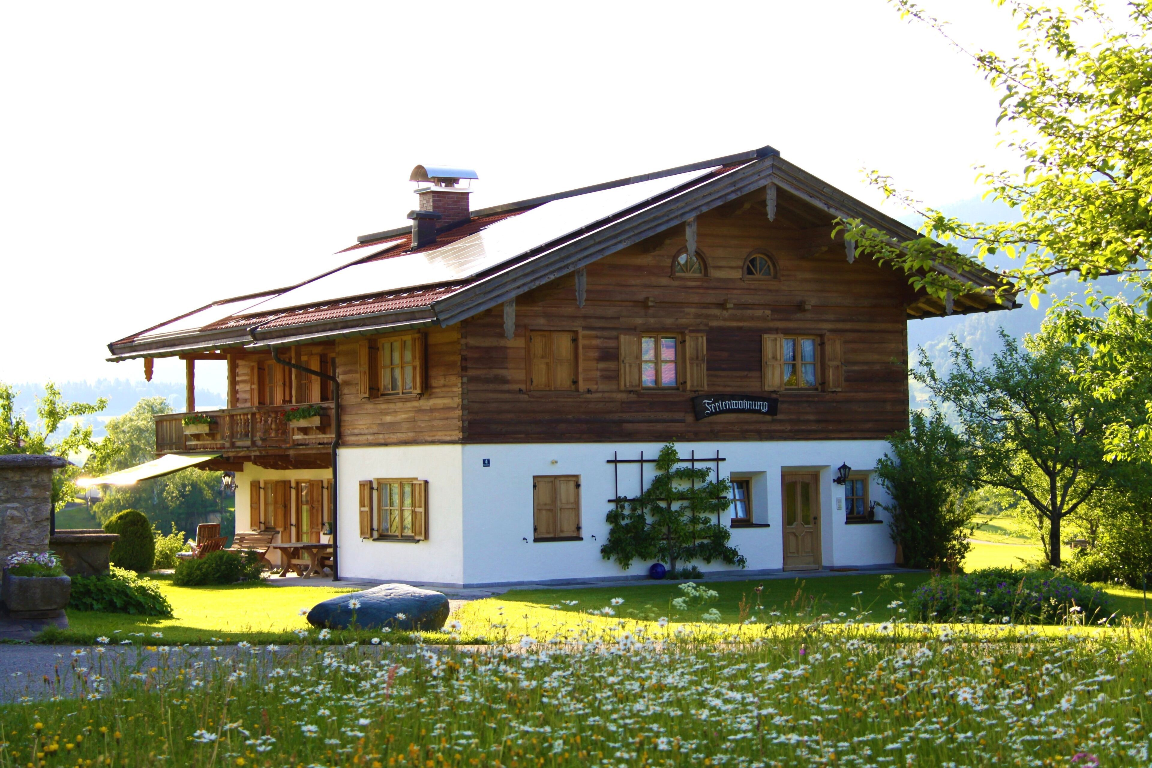 Une maison en bois avec un balcon, une enseigne indiquant « Freundschaftshaus », et un jardin fleuri.