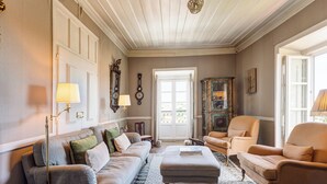 A living room with a beige sofa, a matching armchair, a patterned rug, and a wooden coffee table.