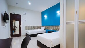 A hotel room with two beds, a desk, a chair, a TV, and a wardrobe. - Grand FC Hotel (George Town)