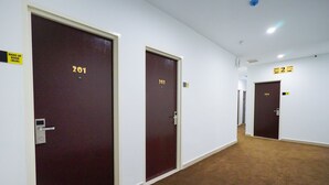 A hallway with doors numbered 201, 202, and 205. - Grand FC Hotel (George Town)