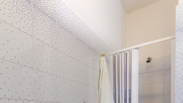 A bathroom with a white sink, a shower with a glass door, and blue tiled flooring. - Residence I PIANETI (San Vito Lo Capo)