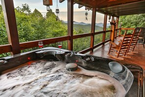 A hot tub with a view of mountains, wooden deck, and outdoor seating. - Moonlight Hideaway | Ellijay, GA (Ellijay)