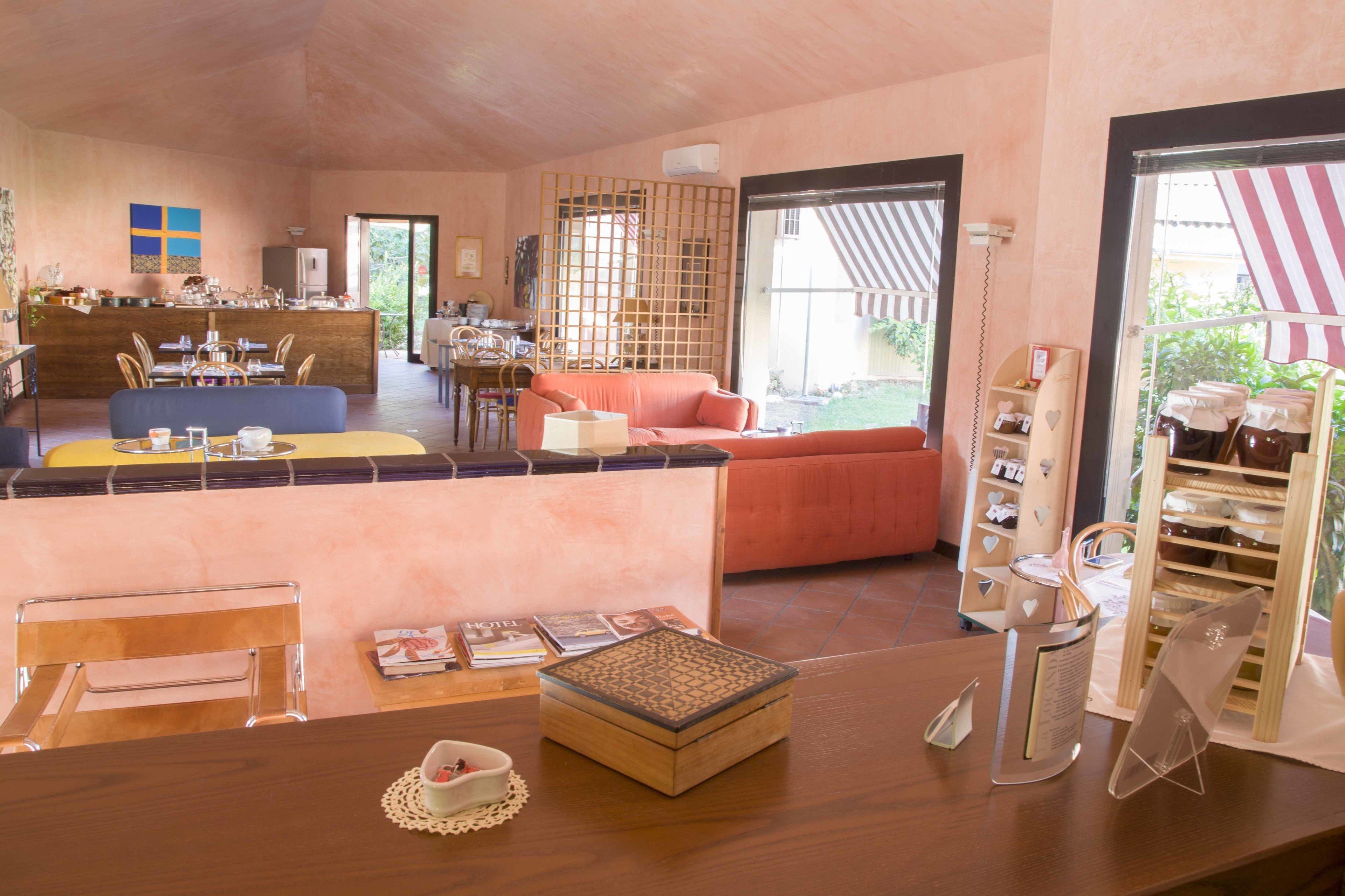Un hall d’hôtel spacieux comprenant un comptoir d’accueil, un espace salon et une vue sur la terrasse extérieure.