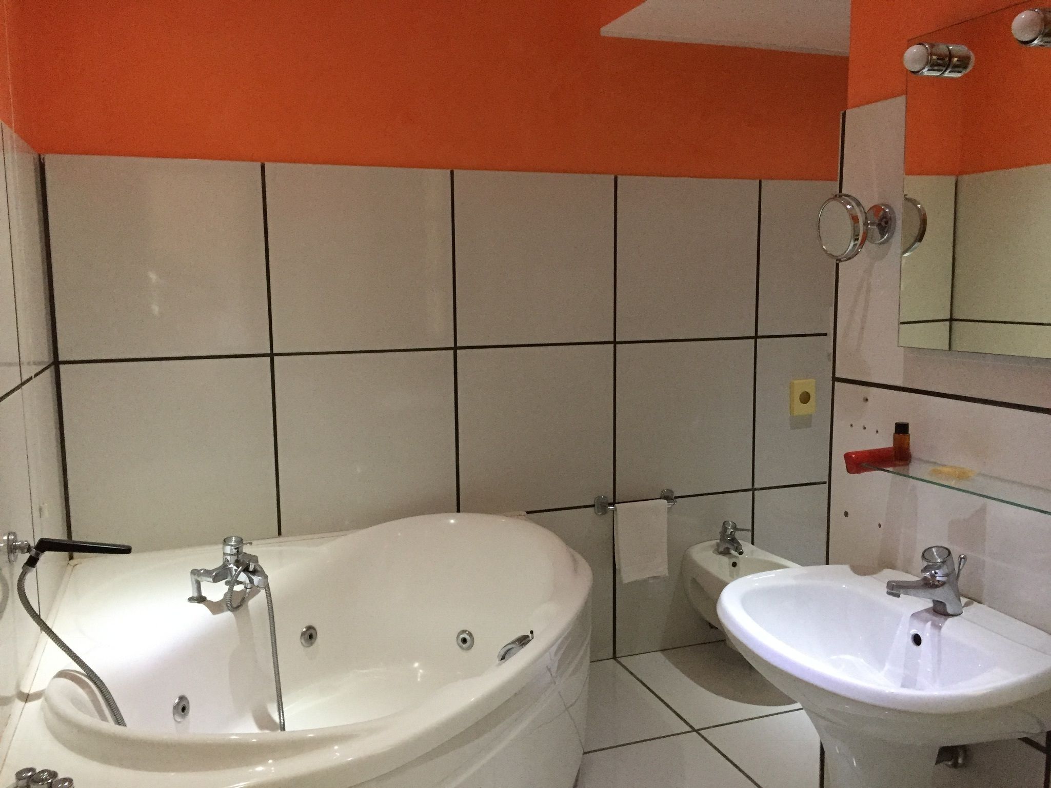 Un baño con bañera, lavamanos y espejo.