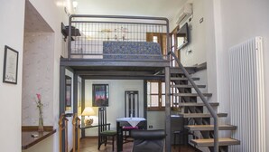 A dormitory room with a bunk bed, a desk, a chair, a table, and a staircase. - Aliajazz hotel (Castrovillari)