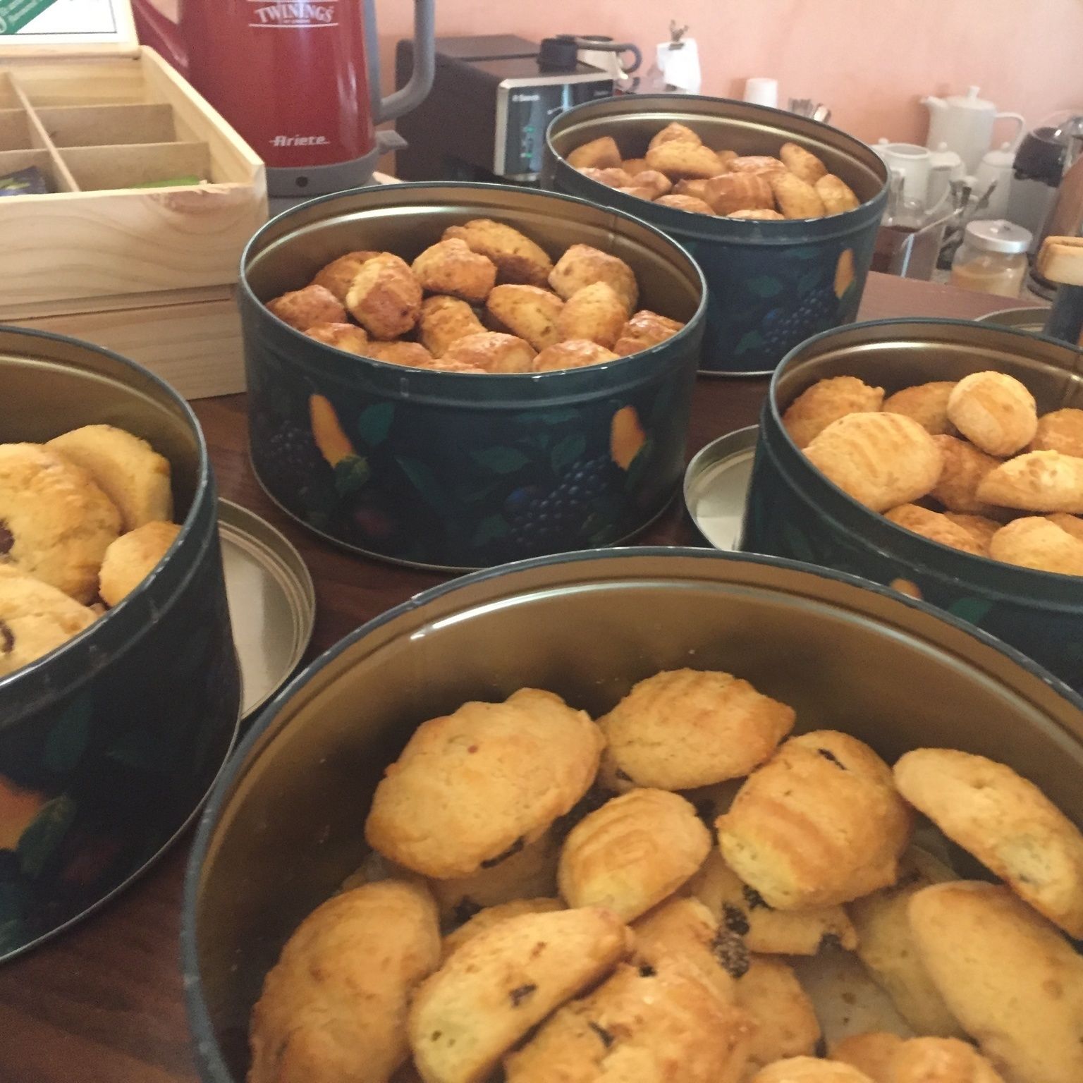 Multiple containers filled with pastries on a table.