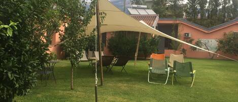 A backyard with a tent, outdoor furniture, and a lawn.