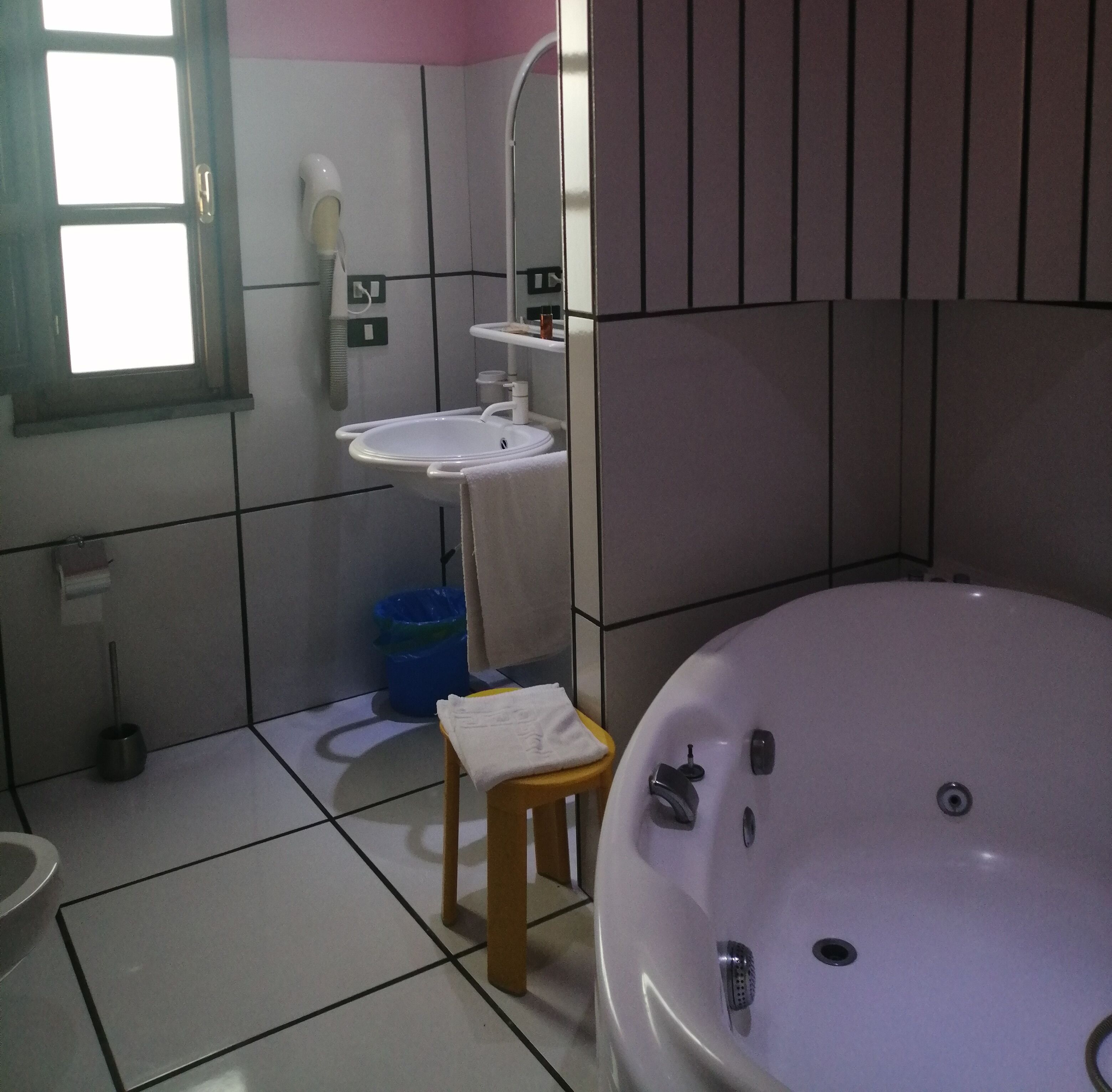 A bathroom with a bathtub, a sink, and a mirror.