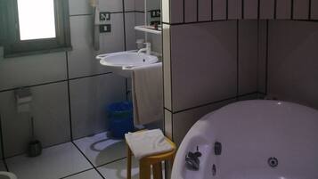 A bathroom with a bathtub, a sink, and a mirror.