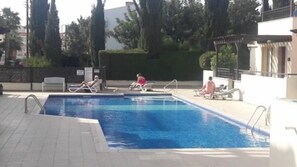 Una piscina al aire libre, sombrillas