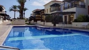 Una piscina al aire libre, sombrillas