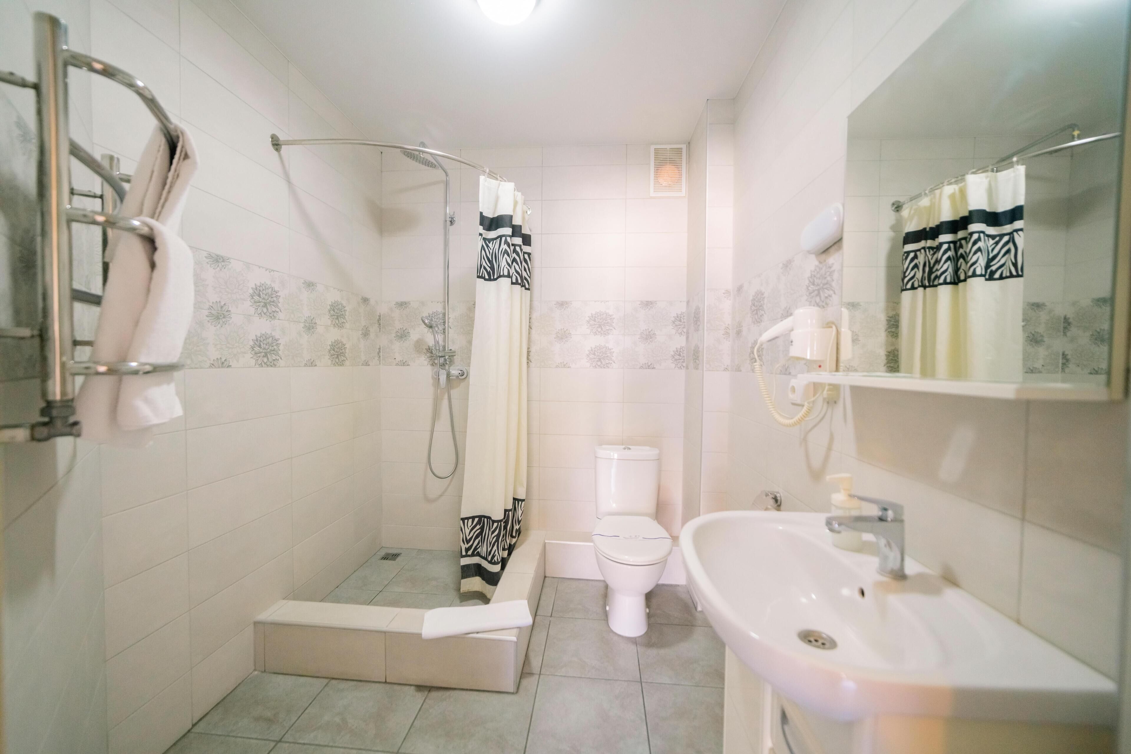 A bathroom with a shower, toilet, and sink.