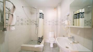 A bathroom with a shower, toilet, and sink.