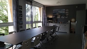 Ett modernt kök med matplats, stora fönster och utsikt över grönområden.