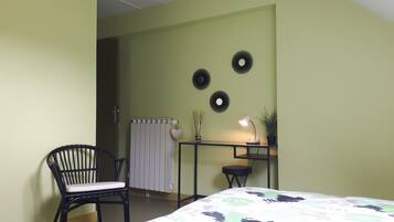 Une pièce comprenant un lit, un bureau avec une lampe, une chaise et des éléments décoratifs sur les murs.