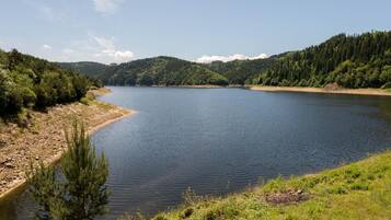 Un lago tranquillo circondato da dolci colline ricoperte di boschi.