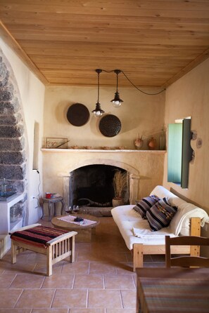 Ein gemütliches Wohnzimmer mit Kamin, Holzmöbeln und einer Steinwand.