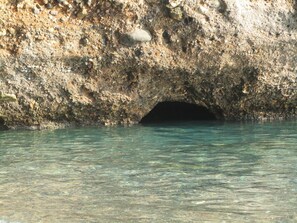 A rocky cave entrance with clear water. - Sitanos Forgotten Neighborhood (Sitia)