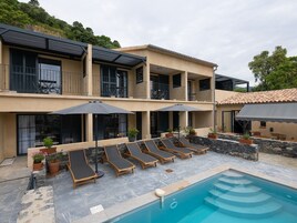 Una piscina al aire libre, sillones reclinables de piscina