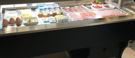 Een bedieningsbalie met diverse etenswaren en sauzen.