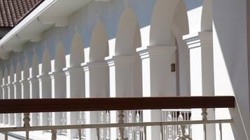 A white fence with pointed tops and a balcony railing.