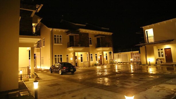 A multi-story building with a parking area in front. - Kiniz Luxury Apartments (Uyo)