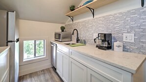 A modern kitchen with white cabinets, a marble countertop, a built-in oven, a sink, and a window with a view of trees. - Dtwn Golden Apt < 9 Mi to Red Rocks Amphitheater! (Golden)
