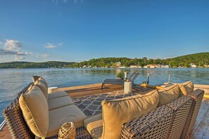A boat deck with wicker furniture, a small table, and a potted plant.