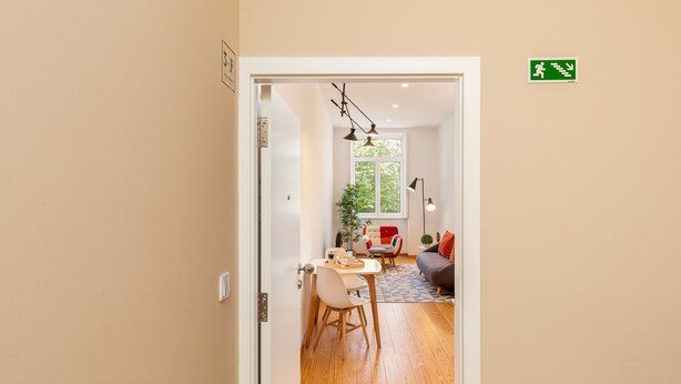 Et moderne interiør med et spiseområde, en sofa og en trappe.